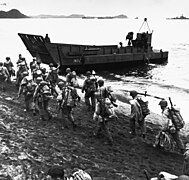 Troops march up the beach at Adak, during pre-invasion loading for the Kiska Operation, 13 August 1943