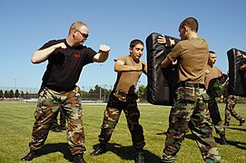 Master-at-Arms 1st Class Doug Terou, left, assigned to Naval Station Everett, Wash., encourages members of the U.S. Naval Sea Cadet Corps to work during a master-at-arms training exercise.