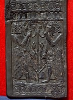 Carved ivory panel showing young bearded Egyptian men flanking lotus stem and flowers. From Nimrud, Iraq. Iraq Museum.
