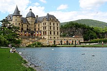 Large chateau on a man-made lake, surrounded by visitors