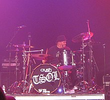 Biuso behind a drum kit that reads "TSOL"