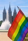 A gay flag with an LDS temple seen in the background