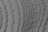 This HiRISE image shows layers running roughly up and down, along with faint polygonal fracturing. Polygonal fractures are mostly rectangular.