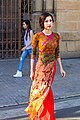 A woman wearing orange round neck áo dài with pattern is walking, February 2015