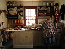 A visiting reenactor in the reconstructed trade shop located in the Great Hall