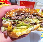 A half-eaten McDonald's Big Mac, showing the contents of the burger