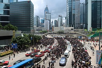 Protesters occupying Harcourt Road while allowing vehicles to leave.