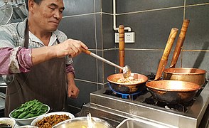 Mixian (米线) rice noodles being cooked in copper pots (铜锅), China