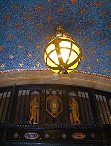 The central section of the lobby. Ornate metalwork is visible in the lower part of the image, while a globe hangs from a blue-and-gold ceiling at the top.