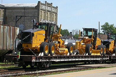 CN flatcar with newly built Volvo graders on the Goderich–Exeter Railway.