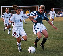 Mia Hamm fighting off a challenge from a German player