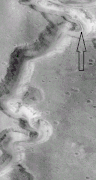 Close view of Nanedi Valles, as seen by Mars Global Surveyor. Arrow points to a small channel that formed after the main valley. This is an enlargement of previous image.