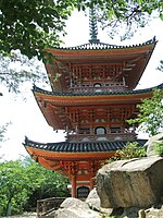Three-storied pagoda with white walls and red beams. There are railed verandas on the two upper stories.