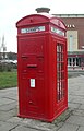 Post box incorporated into a Type K4 telephone kiosk, introduced in 1927. Ten survive in the UK of this design by Sir Giles Gilbert Scott, which also incorporates two stamp vending machines. This red telephone box is in Warrington, Cheshire, England.