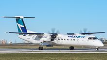 WestJet Encore Q400 aircraft with propellers taxiing at an airport