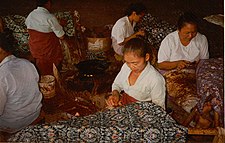 Batik craftswomen in Java handmarking resist on batik tulis cloth with canting
