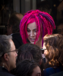 Photograph of a woman with bright pink and purple hair in medium-length dreadlocks