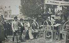 The Duke and Duchess of Saxe-Coburg and Gotha with two other men walking towards an outdoor display of agricultural equipment