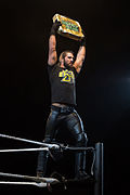 Seth Rollins holds Money in the Bank briefcase at a WWE house show in January 2015