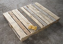 A wooden pallet with a glove on it
