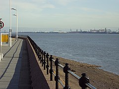Wind turbines on the distant Seaforth Dock, seen from the Promenade at Seacombe, Wirral, England