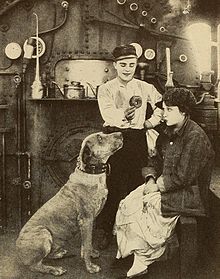 Black and white photo of a young man, a young woman, and a dog