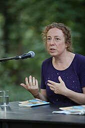 Karin Fellner spricht bei einer Lesung in ein Mikrofon