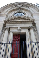 The door and pediment with the statues of charity (right) and religion (left) by Ernest-Eugène Hiolle