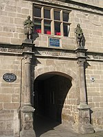 Two stone statues of Philomath and Polymaths in Jacobean dress, on the original buildings; also featured on the contemporary school library