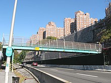 Pedestrian bridge over the parkway to the Hudson River Greenway, north of the Plaza, as seen from the Greenway; in the background is the Castle Village complex.