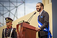 A man (Nayib Bukele) standing at a podium and speaking to a large crowd.