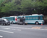 An uyoku gaisensha passing two Tokyo Metropolitan Police Department police buses
