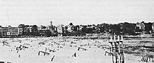 Black and white photograph of a beach with objects on the sand