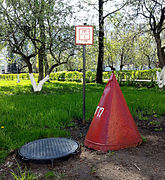 Underground hydrant in Russia, marked with a plate and a red cone