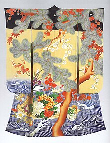 The back view of a long sleeved kimono decorated with a large tree and flowers on a black, yellow and wave-patterned background.