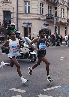 World record winner Tigst Assefa (left) about 25 km (16 mi) into the 2023 Berlin Marathon, alongside pacemaker Girmay Birhanu Gebru