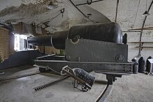 View of the interior of a casemate, which is nearly filled with the bulk of a replica 12.5-inch gun