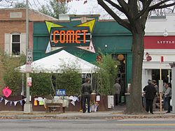A green storefront with a large orange and yellow logo that reads "Comet" in all capital letters.