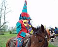A capuchon wearing Mardi Gras on horseback