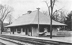 A one-story stone railroad station in the Richardsonian Romanesque style