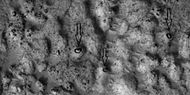 Close view of ejecta, as seen by HiRISE under HiWish program. Note: Arrows show examples of boulders sitting in pits.