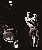 A black and white photo of Iggy Pop performing onstage