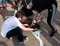 Flushing the eyes of a protester in Minneapolis with milk after exposure to tear gas