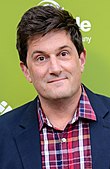 Michael Showalter standing in front of the Montclair Film Festival red carpet backdrop and facing the camera