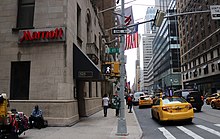 View of the Marriott East Side from the Lexington Avenue sidewalk. The hotel is to the left, and there is a sign with the name "Marriott" on the hotel's facade.
