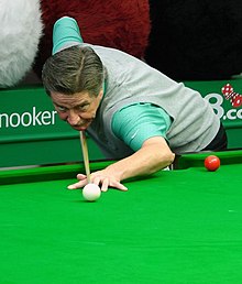 Cliff Thorburn playing a shot at a snooker table