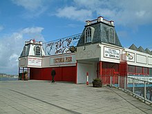 small building with white and red frontage and two small towers
