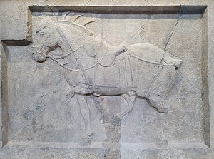 Limestone relief of Quanmaogua ("Curly"). Nine arrows penetrate Quanmaogua, six in front and three in back. On display at the Penn Museum in Philadelphia.