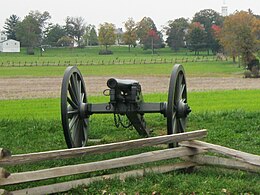 Photo shows a black cannon on an 1800s carriage pointing at the viewer.