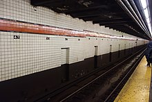view of a subway track and wall from a platform at the 47th–50th Streets–Rockefeller Center station